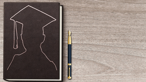 Graduate picture on a book and a pen on the side