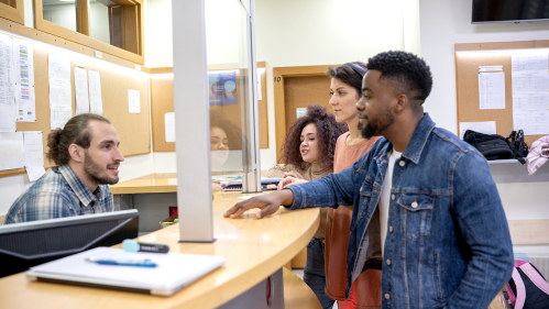 Students talking to someone behind the desk