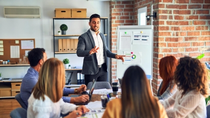 Man presenting to group at table