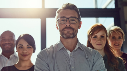Group of individuals posed together with arms crossed.