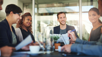 Team of individuals meeting around a table.