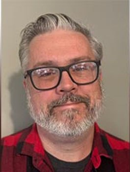Bill Bodkin is wearing glasses and a red and black checked shirt in this headshot.