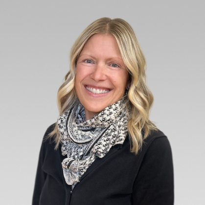 Clair Carter-Ginn, in this headshot, is wearing a black sweater and a black and white scarf.