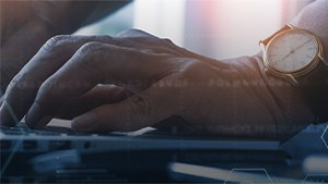 This stock images shows a hand typing on a computer keyboard. The background is blue.